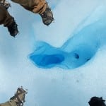 Steigeisen um ein blaues Eisloch