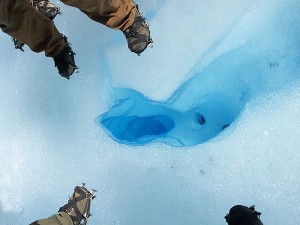 Steigeisen um ein blaues Eisloch